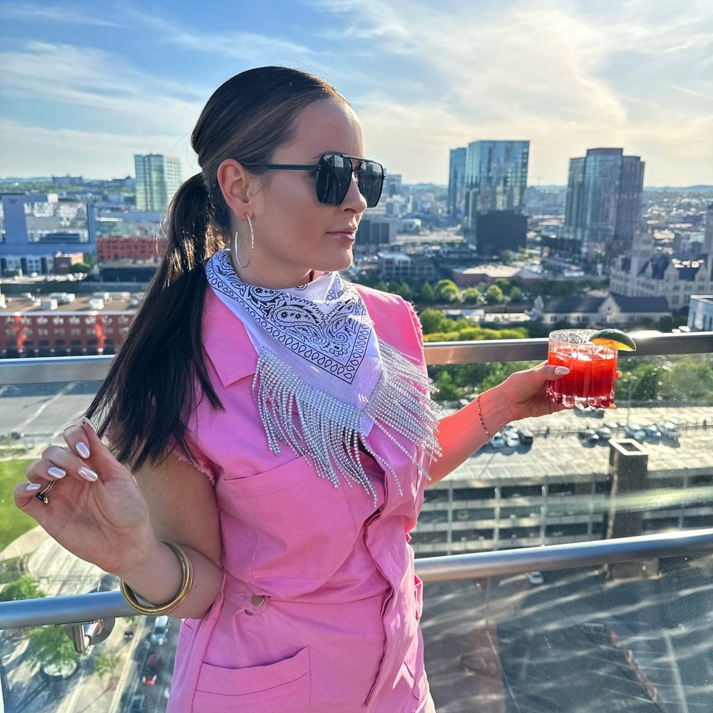 Pink denim romper with gold hardware, buttons half way up the front